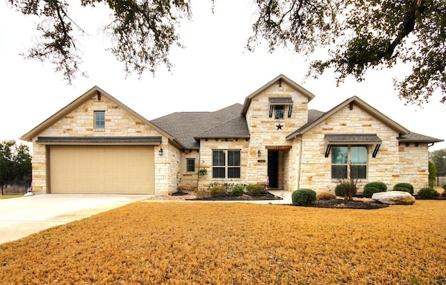 view of front of house featuring a front yard, roof with shingles, driveway, and an attached garage