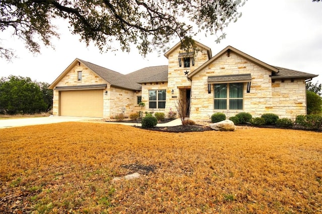 view of front of house featuring a front lawn, concrete driveway, a shingled roof, and an attached garage