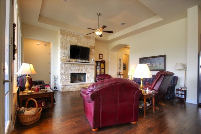 living room with a tray ceiling, a fireplace, and hardwood / wood-style flooring