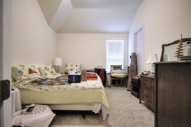 bedroom featuring lofted ceiling and light carpet