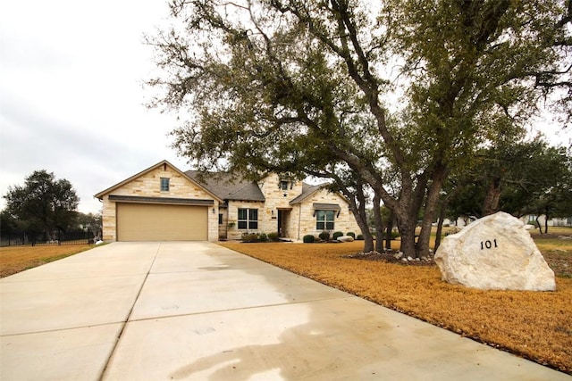 view of front of property with a garage, stone siding, and driveway