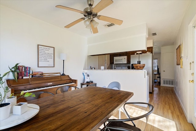 dining space with ceiling fan, visible vents, and light wood-style floors