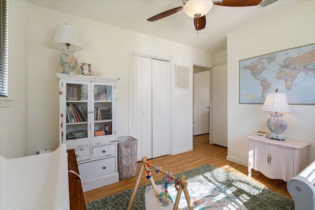 bedroom with baseboards, a closet, a ceiling fan, and wood finished floors