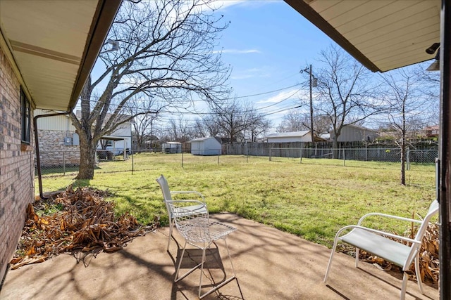 view of yard with a fenced backyard, an outbuilding, and a patio