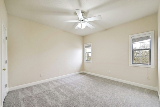 spare room with a ceiling fan, carpet, and baseboards