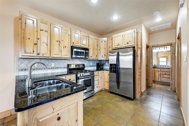 kitchen featuring visible vents, appliances with stainless steel finishes, a sink, and light brown cabinetry