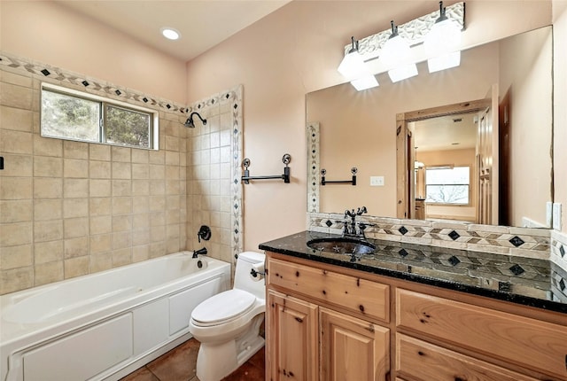 bathroom with a wealth of natural light, bathing tub / shower combination, vanity, and toilet