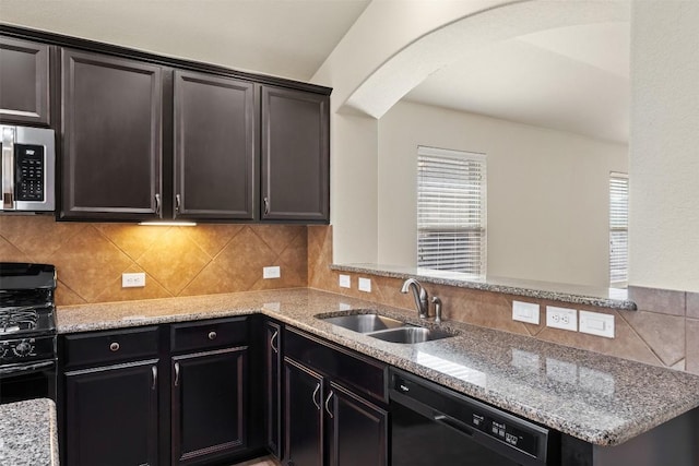 kitchen featuring decorative backsplash, a sink, black appliances, and light stone countertops