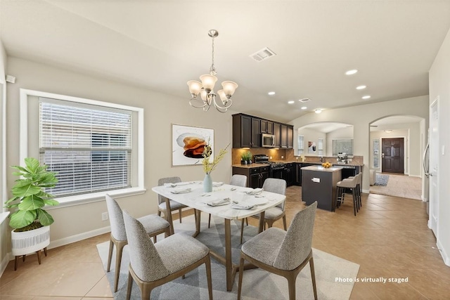 dining room with light tile patterned floors, visible vents, arched walkways, a notable chandelier, and recessed lighting