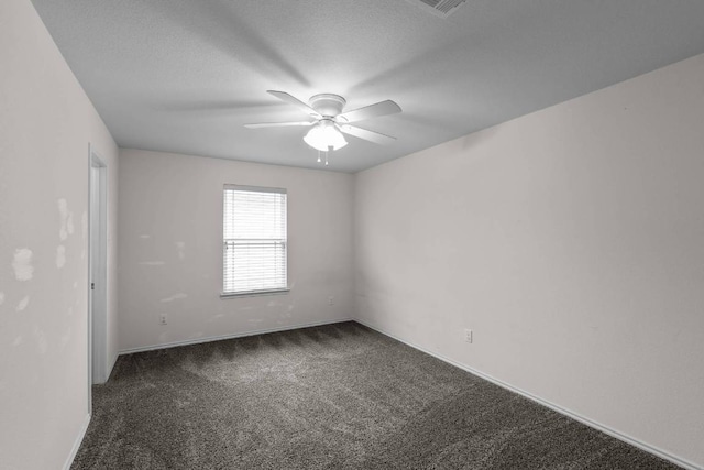 carpeted empty room with a textured ceiling and a ceiling fan