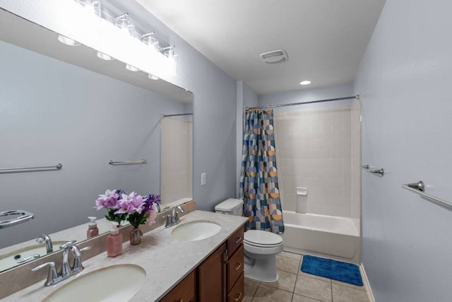 bathroom with double vanity, tile patterned flooring, a sink, and toilet