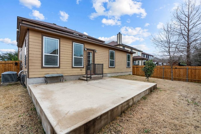 back of property featuring central AC, a chimney, a patio area, and a fenced backyard