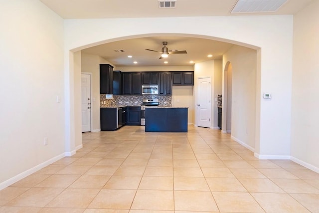 kitchen featuring light tile patterned floors, visible vents, ceiling fan, appliances with stainless steel finishes, and backsplash