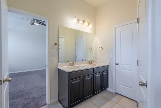 full bathroom featuring double vanity, baseboards, a sink, and tile patterned floors