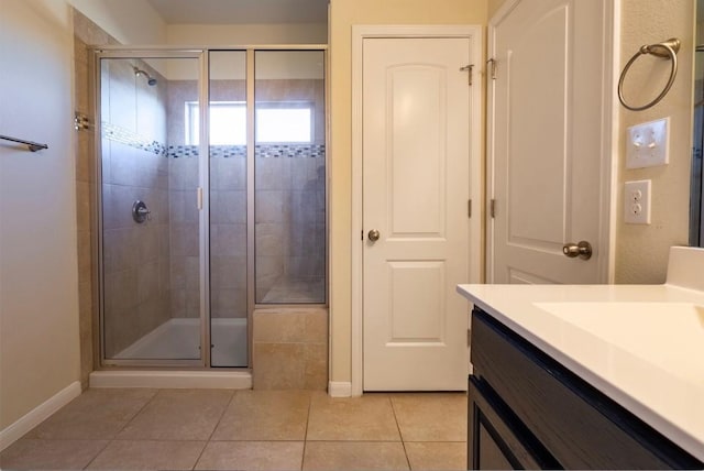 bathroom featuring baseboards, a stall shower, vanity, and tile patterned floors