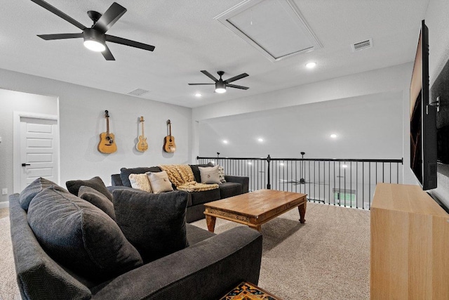 living area featuring attic access, visible vents, and a ceiling fan