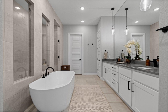 bathroom featuring double vanity, a soaking tub, tile patterned flooring, a shower stall, and a sink