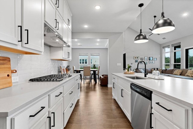 kitchen featuring under cabinet range hood, stainless steel appliances, a sink, light countertops, and dark wood finished floors