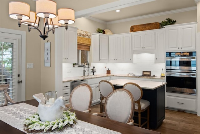 2216 Garden Ct, San Marcos, TX 78666 - kitchen with stainless steel double oven, a kitchen island, tasteful backsplash, white cabinets, and crown molding