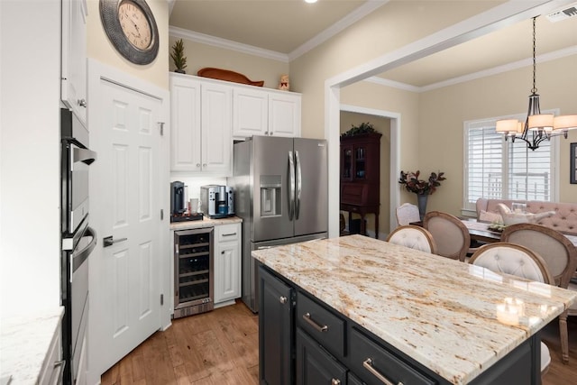 kitchen with wine cooler, a kitchen island, visible vents, white cabinets, and stainless steel fridge