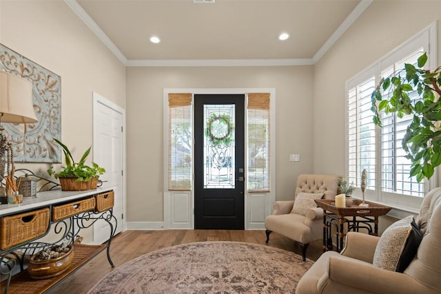 foyer entrance featuring recessed lighting, baseboards, crown molding, and light wood finished floors