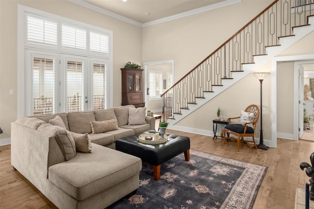 living area with ornamental molding, stairway, hardwood / wood-style flooring, and baseboards