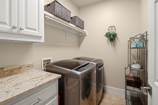 washroom with cabinet space, light tile patterned floors, baseboards, and separate washer and dryer