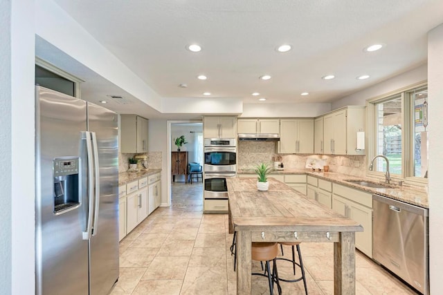 4113 Rimrock Dr, Lago Vista, TX 78645 - kitchen with appliances with stainless steel finishes, under cabinet range hood, decorative backsplash, recessed lighting, and light stone counters