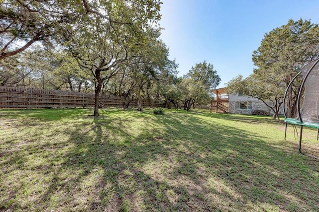 4113 Rimrock Dr, Lago Vista, TX 78645 - view of yard with a trampoline and fence