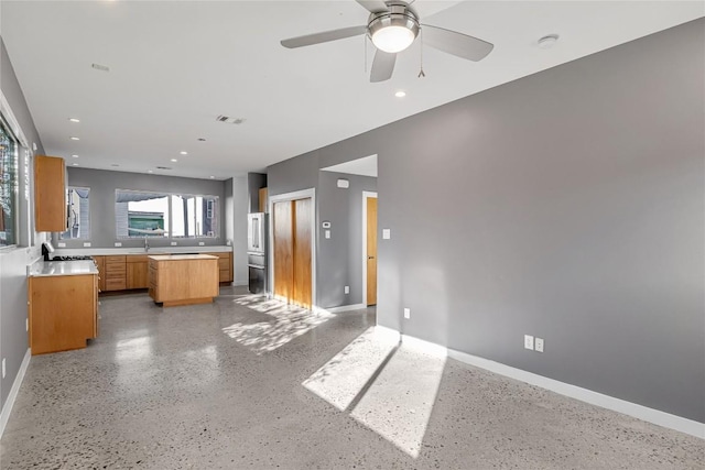 kitchen with light countertops, a sink, visible vents, and baseboards