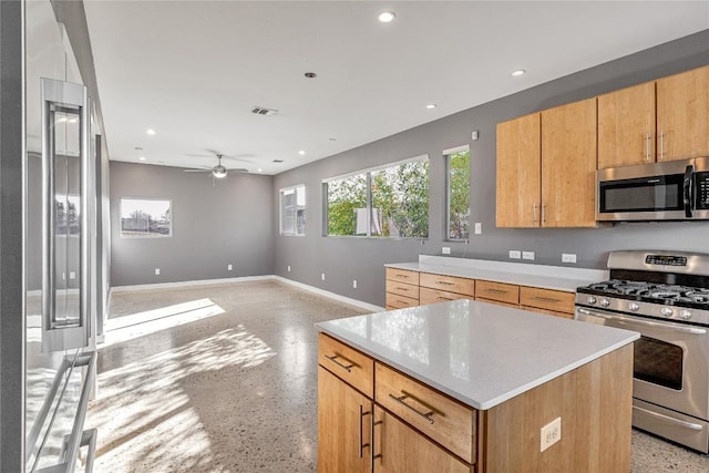 kitchen featuring baseboards, a kitchen island, stainless steel appliances, light countertops, and recessed lighting