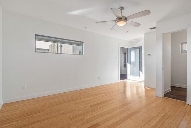 empty room featuring light wood-style flooring, visible vents, ceiling fan, and baseboards