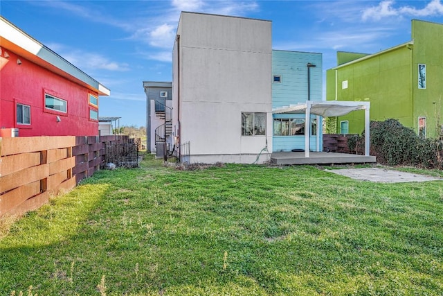 back of house featuring a pergola and a yard