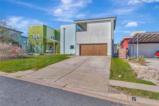 contemporary home with a garage, a front yard, concrete driveway, and stucco siding