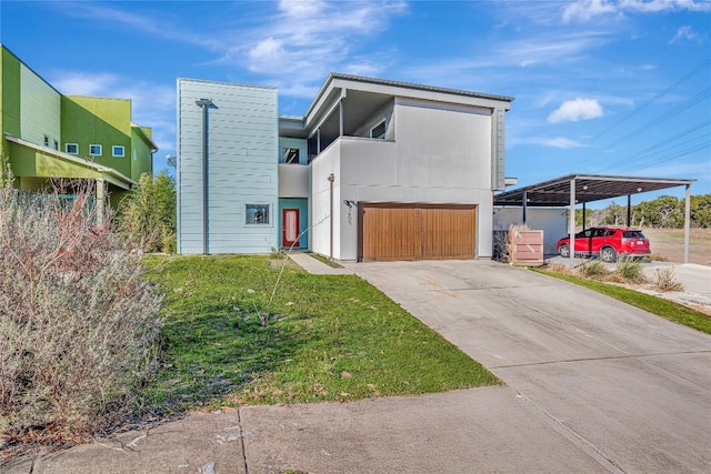 contemporary home featuring driveway, an attached garage, a front lawn, a carport, and stucco siding