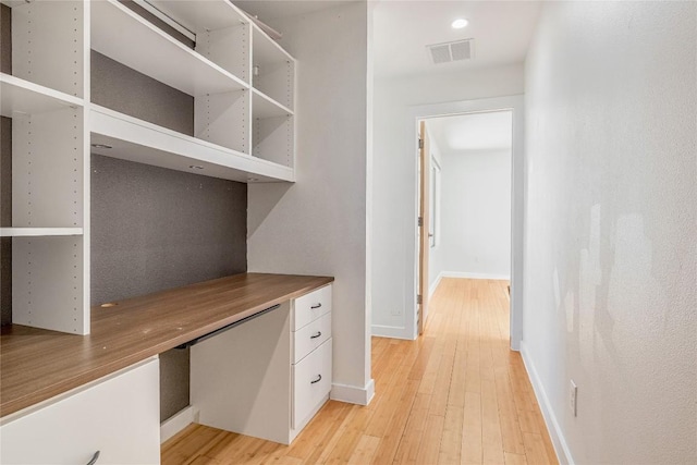 unfurnished office featuring baseboards, visible vents, and light wood-style floors