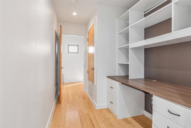 unfurnished office featuring baseboards, recessed lighting, built in study area, and light wood-style floors