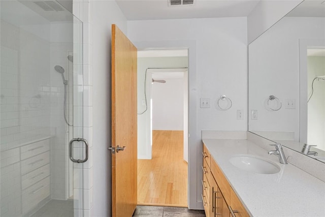 bathroom featuring a stall shower, visible vents, wood finished floors, and vanity