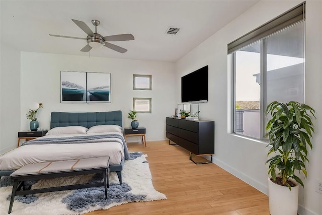 bedroom with ceiling fan, baseboards, visible vents, and light wood-style floors