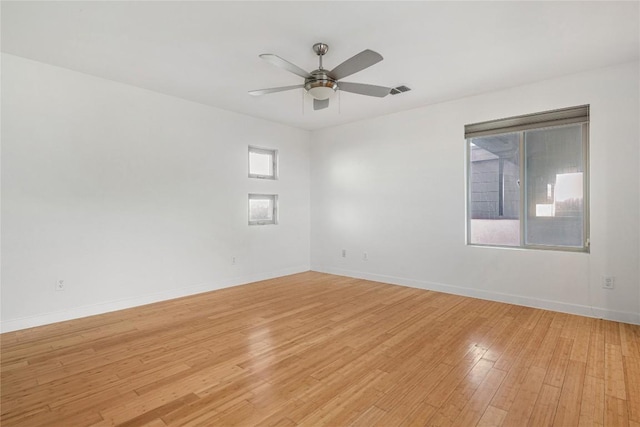 empty room featuring light wood-style floors, ceiling fan, and baseboards