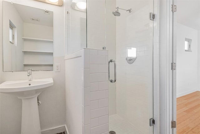 bathroom featuring a shower stall, visible vents, baseboards, and wood finished floors