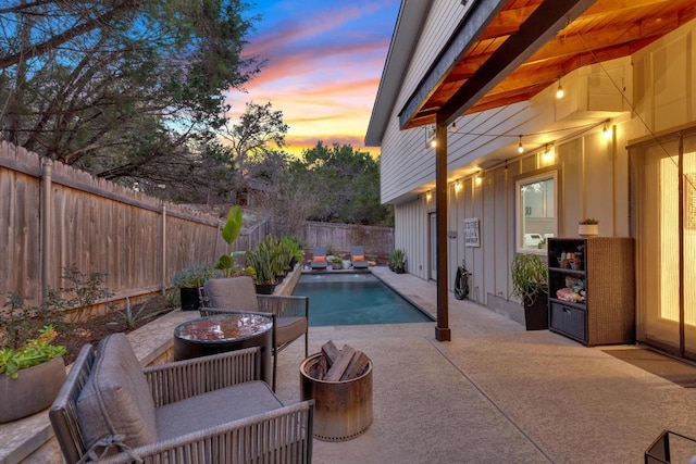 pool at dusk featuring a patio area, a fenced in pool, and a fenced backyard