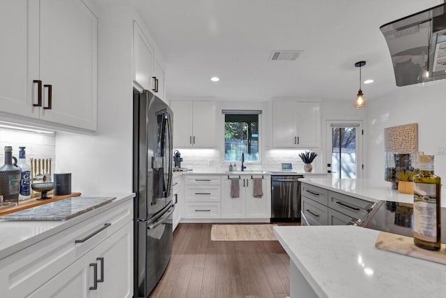 632 Galston Dr, Spicewood, TX 78669 - kitchen featuring stainless steel dishwasher, freestanding refrigerator, recessed lighting, backsplash, and light stone counters
