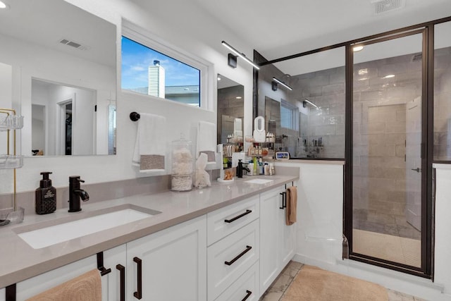 bathroom featuring visible vents, a stall shower, and a sink