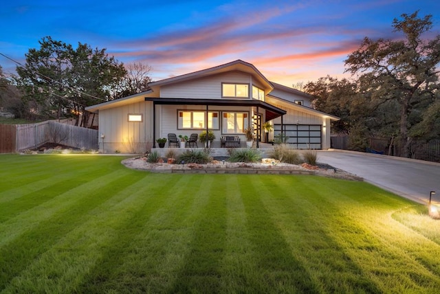 view of front of home featuring driveway, a porch, fence, board and batten siding, and an attached garage