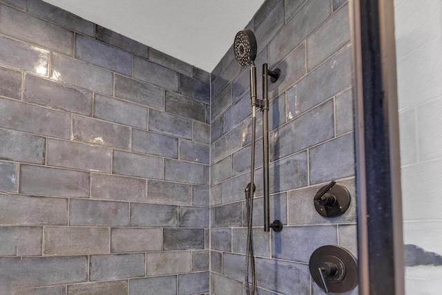 interior details featuring a tile shower