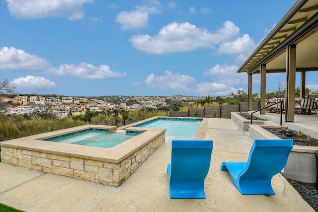 outdoor pool featuring an in ground hot tub, fence, and a patio