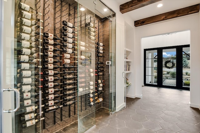 wine room featuring baseboards and beamed ceiling