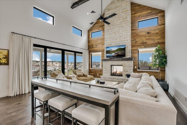 living room with dark wood-style floors, plenty of natural light, wood walls, and a multi sided fireplace