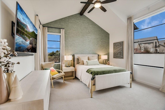 bedroom featuring beam ceiling, a ceiling fan, an accent wall, light carpet, and high vaulted ceiling